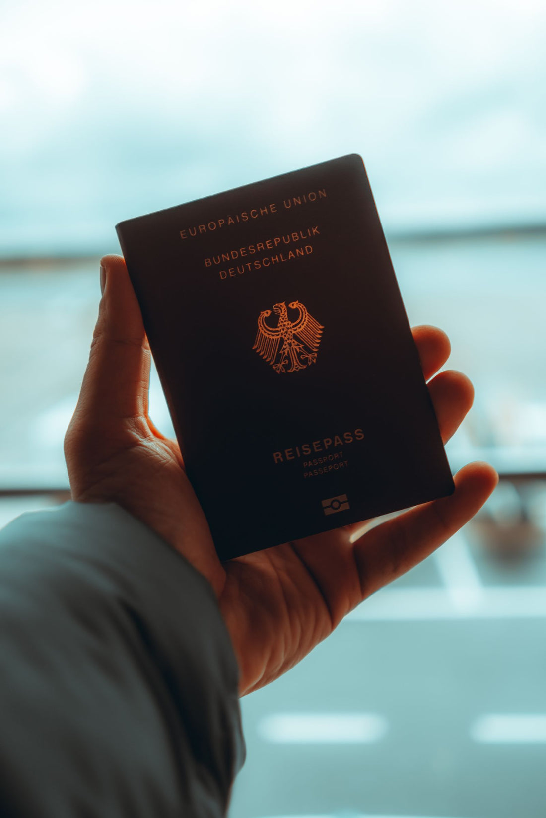 Mano sosteniendo un pasaporte, simbolizando los requisitos de vigencia para viajar en 2026